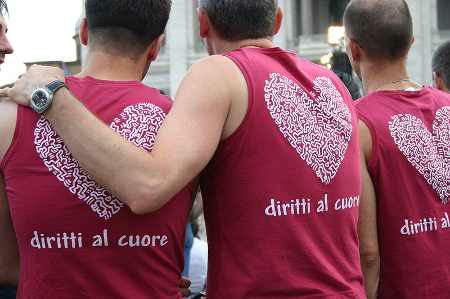 Coppia gay con maglietta con scritta Diritti al cuore.